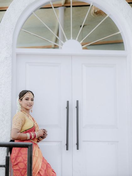 The bride posing by a large white door. We use architectural elements to frame our subjects and add a sense of scale and elegance to our portraits.