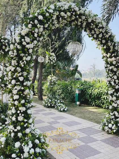 A detail of the floral arch, with hanging crystal orbs that catch the sunlight.