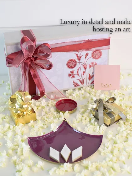 Luxury is in the detail. This image showcases a piece from our 'Symbols of Celebration' collection in a rich purple, styled with kaju katli, demonstrating how our designs make the art of hosting feel special.