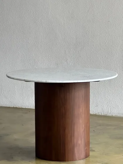 A minimalist dining or center table featuring a solid white marble top on a cylindrical wooden base. This piece showcases my ability to work with mixed materials to create modern, sculptural furniture.