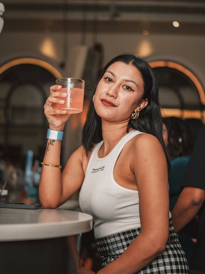 A stylish guest at the bar, enjoying a drink and the sophisticated atmosphere of the mansion.