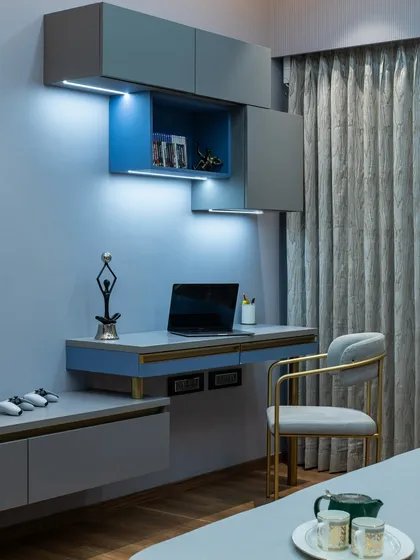 A view of the integrated study nook within this modern blue bedroom. The floating shelves and desk provide a functional workspace without cluttering the serene environment.