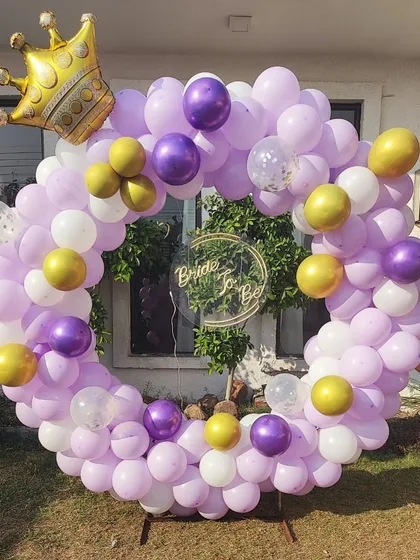 For this outdoor bridal shower, I used a color palette of lavender, purple, and gold balloons on a circular frame. A large gold crown foil balloon adds a playful and regal touch to the "Bride to be" theme.