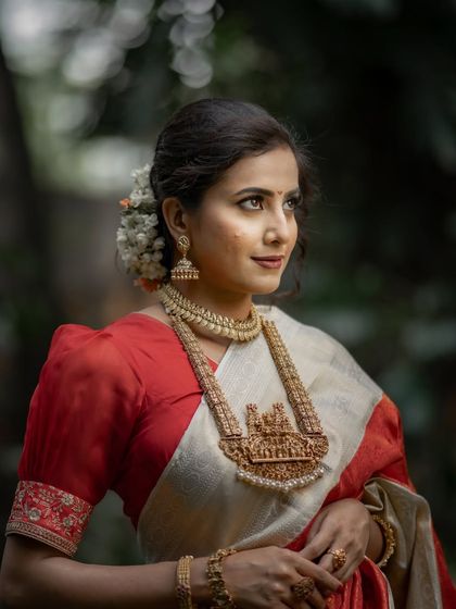 A closer look at the exquisite temple necklace and the fine details of the red brocade on the Kanchipuram saree. Every element comes together to create a look of divine beauty for the bride.