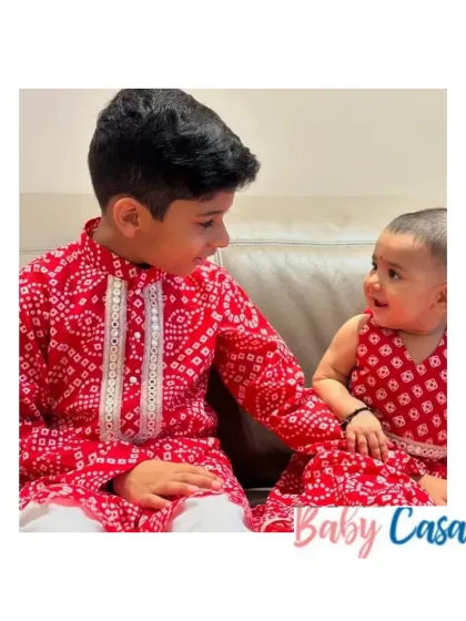 A beautiful moment between a brother and his baby sister, both dressed in our red bandhani print twinning outfits. A perfect look for celebrating their bond during a festival.