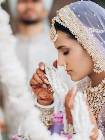A close-up of the bride during the Varmala ceremony. This shot focuses on her delicate features and the emotion of the moment.