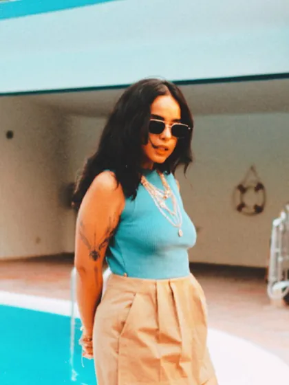 A cool, casual pose by the pool. This photo captures a laid-back, summery vibe, perfect for daytime events or more relaxed musical sets.
