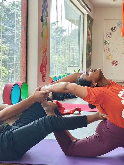 Partner work is essential for learning how to support others. Here, two students work together in an assisted lunge and backbend, building both flexibility and a sense of connection.