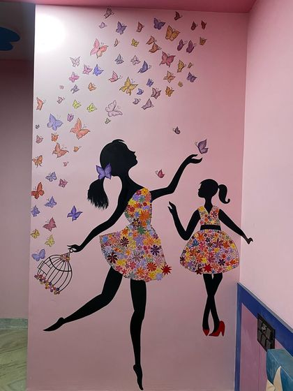 A beautiful and colorful mural for a sisters' room. It features the silhouettes of two girls, one older and one younger, dancing as a flutter of butterflies is released from a cage. The floral dresses add a lovely, detailed touch.