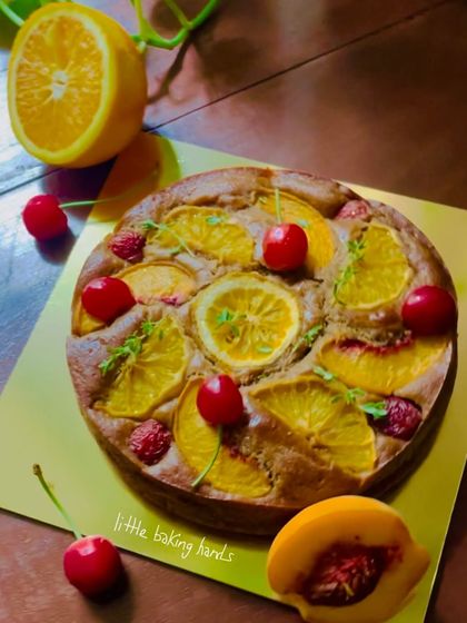 A colourful cake featuring peaches, oranges, and cherries. A true celebration of seasonal fruits.