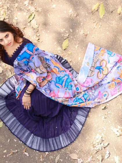 A top-down perspective of the model seated on the ground. This angle allows the full skirt and the beautiful dupatta to spread out, creating a lovely composition.
