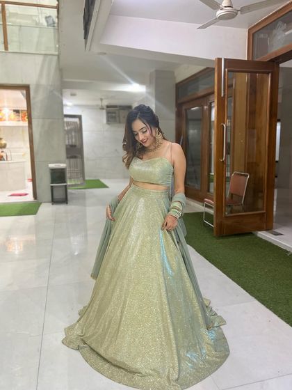 A full shot of the mint green lehenga indoors. This gives a clear view of the outfit's silhouette and color.