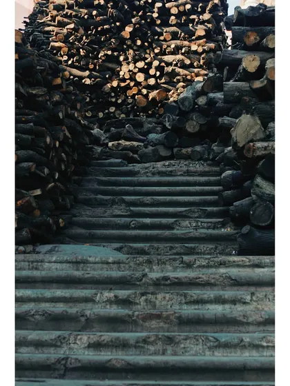A slightly different perspective of the steps and stacked wood at the cremation ghat. The image confronts the reality of life's end, which in Varanasi is not hidden but is a sacred part of the city's existence.