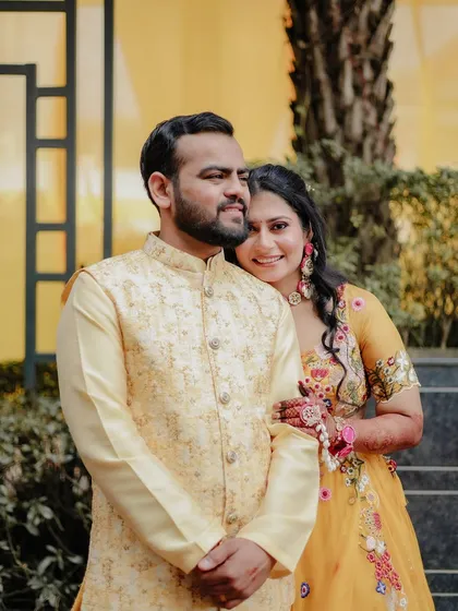 A sweet couple portrait from a mehendi or haldi function, with the bride leaning on the groom's shoulder.
