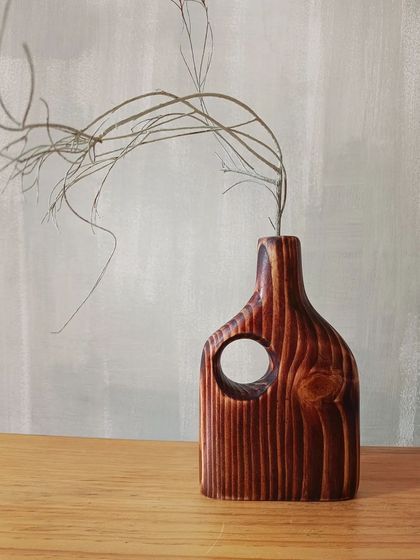 The beautiful, deep-red stain on this wooden vase highlights the natural lines and knots in the pine wood, making each piece truly one-of-a-kind.