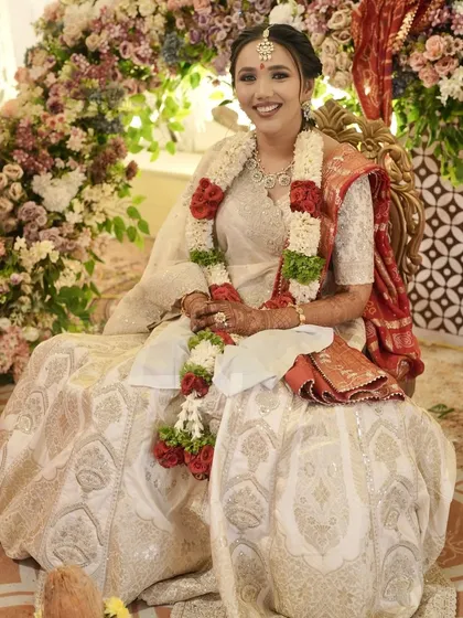 A seated portrait of the bride against a stunning floral backdrop.