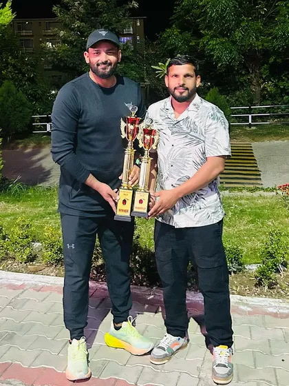 Holding the trophies after a successful tournament.