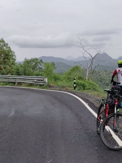 A rider pauses to take in the expansive view of the Palani Hills. Our tours are paced to allow for moments like this, where you can stop, breathe, and appreciate the incredible landscape you're cycling through.