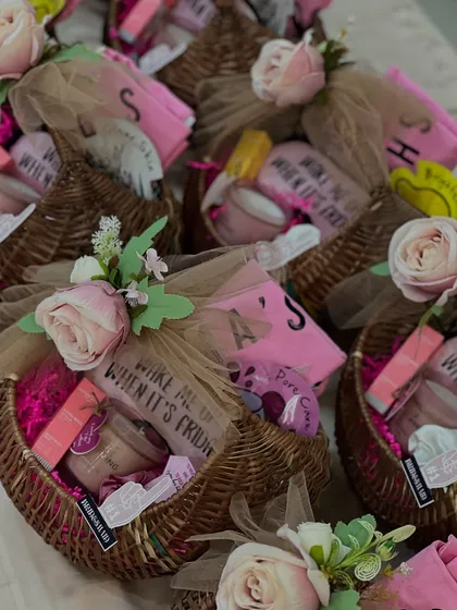 For a more rustic and charming feel, these bridesmaid gifts were packed in lovely wicker baskets. Each one is filled with pampering essentials and personalized items, adorned with a soft pink rose.