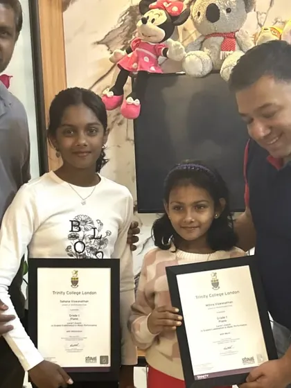 Two talented sisters proudly display their Trinity College London certificates alongside their father and me. We believe in celebrating every milestone, and these moments of recognition are incredibly important for our young performers.