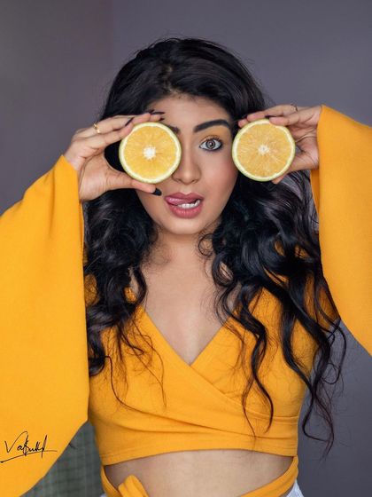 A repeat of the 'two orange eyes' shot. The bright, cheerful colors and playful pose make this a memorable and engaging portrait.