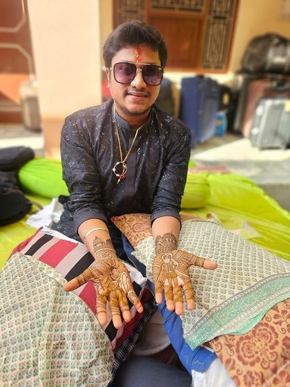 Another angle of the groom's intricate henna. You can see the detail on the palms, with each hand featuring a different central design, making his wedding mehndi truly one of a kind.