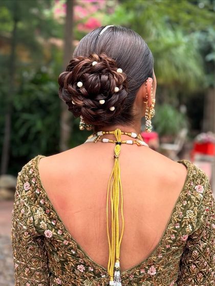 A closer look at the intricate weaving of this messy bridal updo, adorned with pearls.