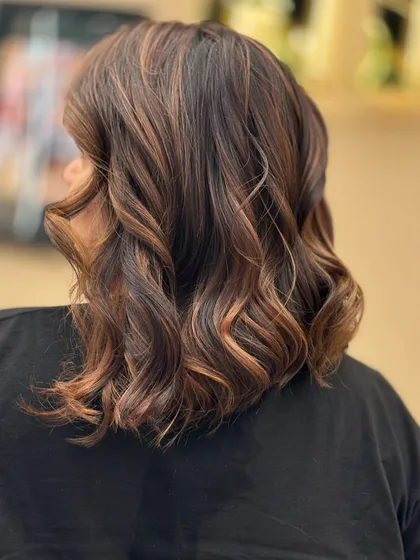 The back view of a creative color application, with seamless blends and vibrant tones styled into soft, modern waves.