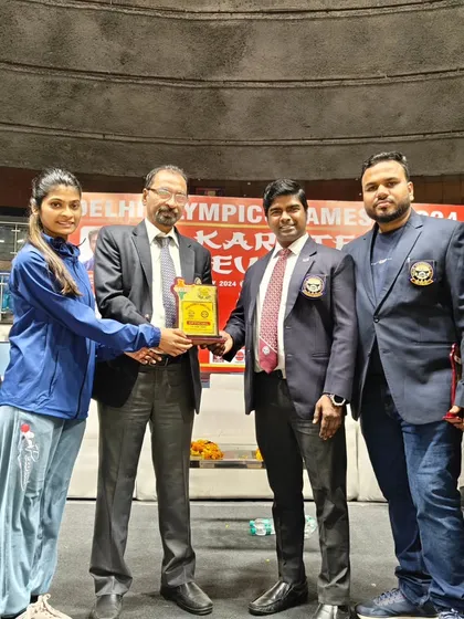 Receiving a memento at the Delhi Olympic Games Karate Event. It is an honor to be recognized among the officials and organizers of such major events.