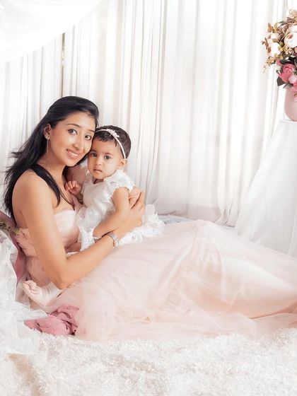 A beautiful portrait of a mother and her child. The soft pinks and whites, combined with the loving embrace, make this a truly tender and timeless image.