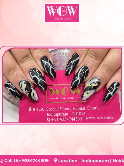 A bold and graphic design featuring black marble with gold foil accents. This look on long, stiletto nails is dramatic, luxurious, and guaranteed to turn heads.