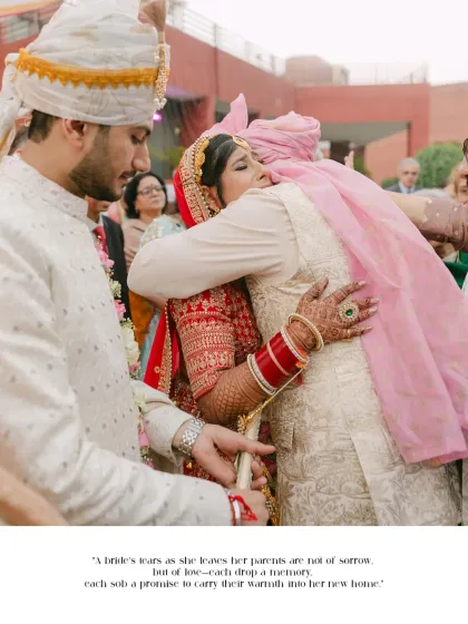An emotional and poignant moment as the bride hugs her parents goodbye. This image captures the bittersweet tears of leaving home to start a new life, a powerful memory for any family.