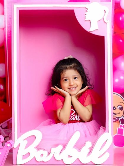 Posing perfectly in her Barbie box. This shot is all about capturing that doll-like cuteness and playful personality.