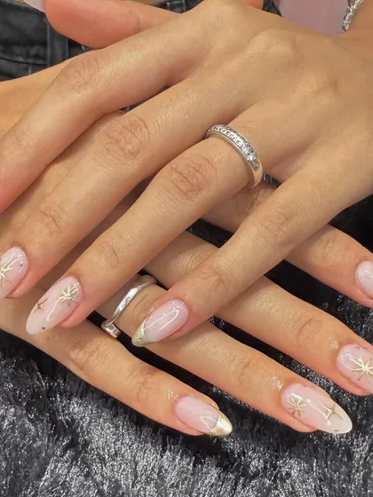 A celestial-inspired design that's both elegant and modern. This set features a sheer, shimmery base with delicate gold French tips and hand-painted gold starbursts.
