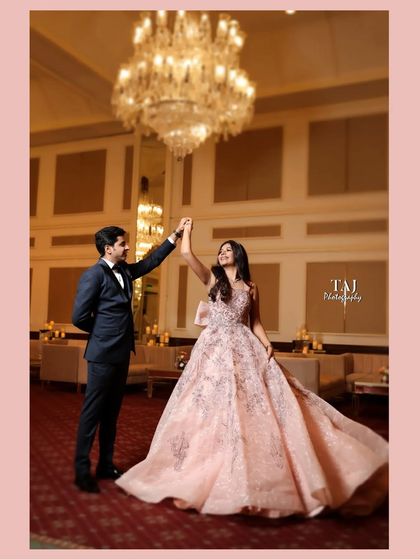 A fairytale moment under a grand chandelier. This shot captures the elegance and romance of a first dance at a beautiful reception venue.