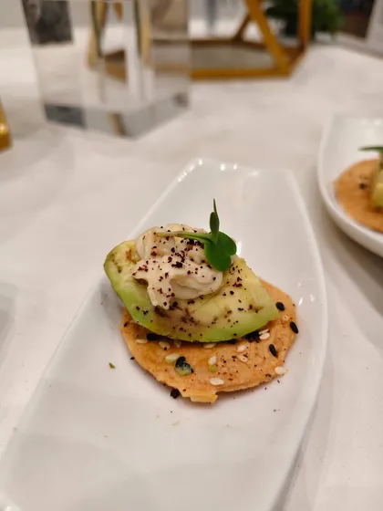 A crunchy sesame cracker topped with creamy avocado, a swirl of cheese, and a sprinkle of spices that hit just right. Proof that sophistication can fit into a single bite.