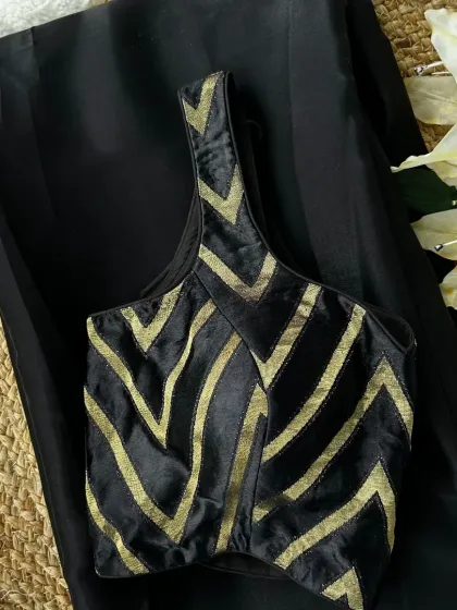 For a more formal or classic look, this black and gold patterned blouse is a perfect choice. Its bold design pairs beautifully with a simple black or gold saree for a sophisticated ensemble.