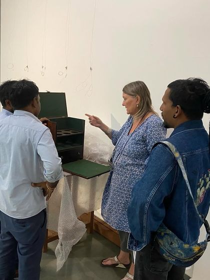 Clare Arni discussing the placement of a display case with the installation team.