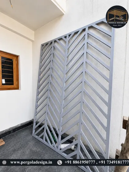 A custom-fabricated privacy screen with a modern chevron pattern. Made from powder-coated metal, these panels are a stylish way to add privacy to a balcony, terrace, or garden area.