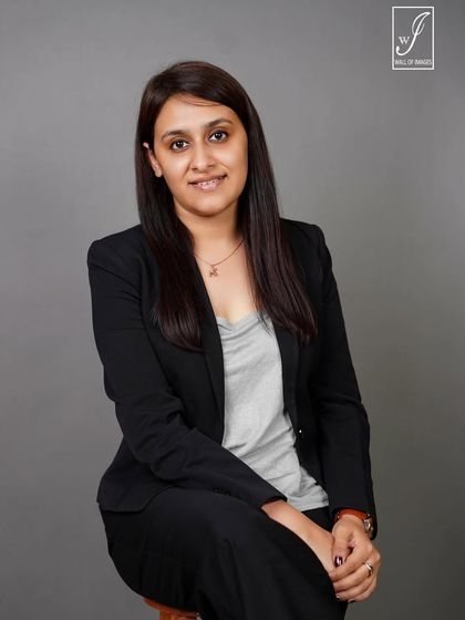 A classic seated headshot with a warm and engaging expression.