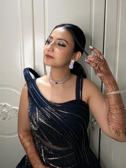 A playful pose showing off the details of her cocktail glam. The shimmering eye makeup and flawless skin are ready for a night of photos and fun.