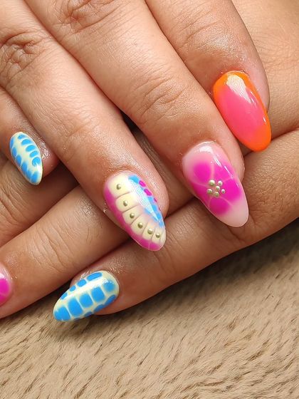 Another angle of this eye-catching custom nail art, highlighting the combination of bright colors, floral designs, and textured patterns for a truly unique look.