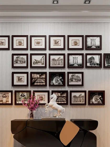 A gallery wall of black and white photographs creates a timeless and personal feature in this apartment. We carefully arrange artwork to create a balanced and visually compelling composition.