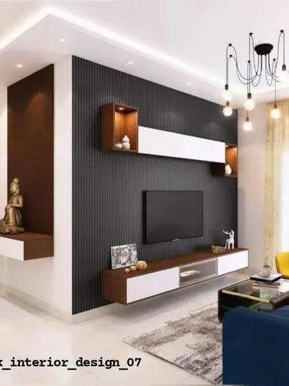 A contemporary TV unit design featuring a dark fluted panel wall and a floating console. A small section is dedicated to a Buddha statue, creating a peaceful corner within the living area.