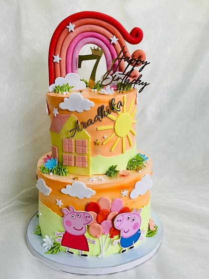 Another angle of the two-tier Peppa Pig cake, showing the house and sun details.