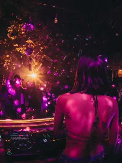 A view from behind the decks, looking out at a sea of people dancing under the stars and disco balls. This is my happy place.