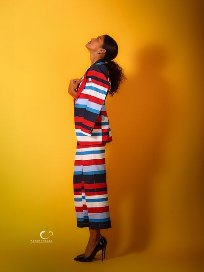 A side profile that highlights the unique cut of the suit and her elegant posture. The shadow adds depth and drama.