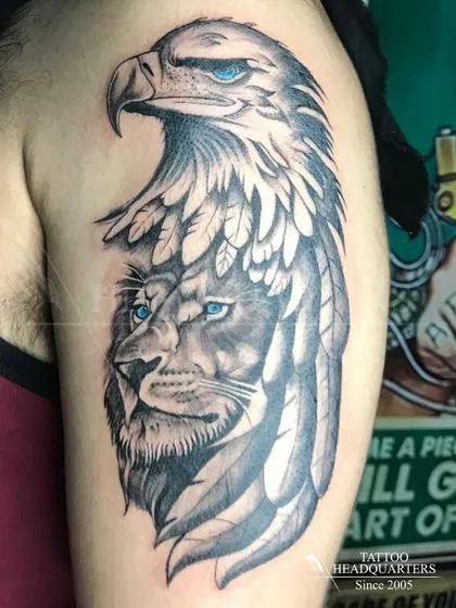 A powerful composite tattoo merging the faces of a lion and an eagle, both with striking blue eyes. This piece symbolizes strength, vision, and freedom.