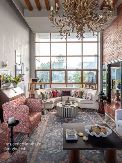 This living room in Dhaka was designed to be both functional and elegant. The curved sofa softens the grand scale of the room, while the custom furniture and layered textiles add a personal, welcoming touch. It's a space that tells a story of a well-travelled life.