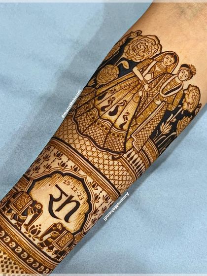 A full arm view showing a custom couple portrait combined with personalized initials, elephants, and other traditional motifs, creating a unique and meaningful design.